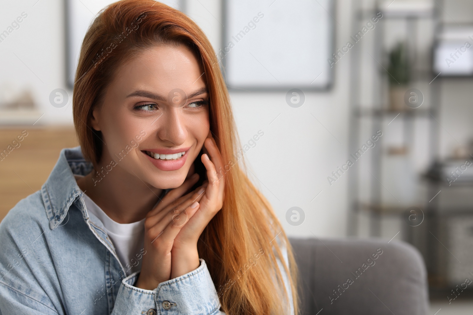 Photo of Portrait of beautiful smiling young woman. Happy lady with red hair at home. Space for text