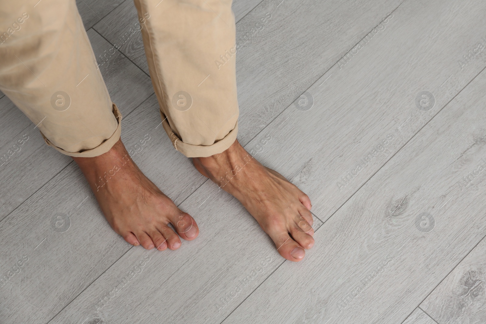 Photo of Man walking barefoot at home, closeup. Floor heating concept