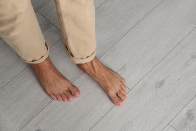 Photo of Man walking barefoot at home, closeup. Floor heating concept