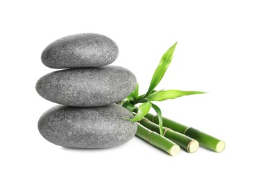 Photo of Stack of spa stones and bamboo stems on white background