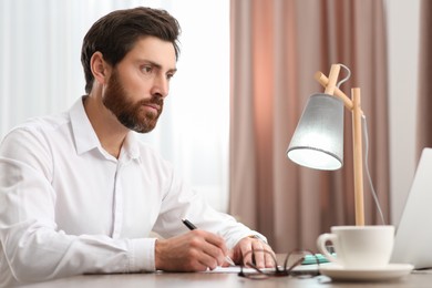 Photo of Businessman working with documents at wooden table in office