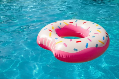 Inflatable ring floating in swimming pool on sunny day