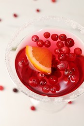 Tasty cranberry cocktail in glass on white table, above view