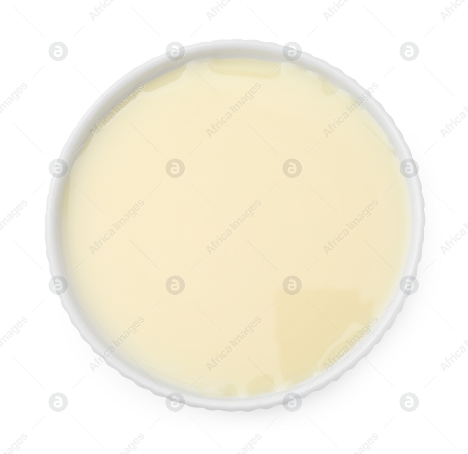 Photo of Bowl with condensed milk isolated on white, top view