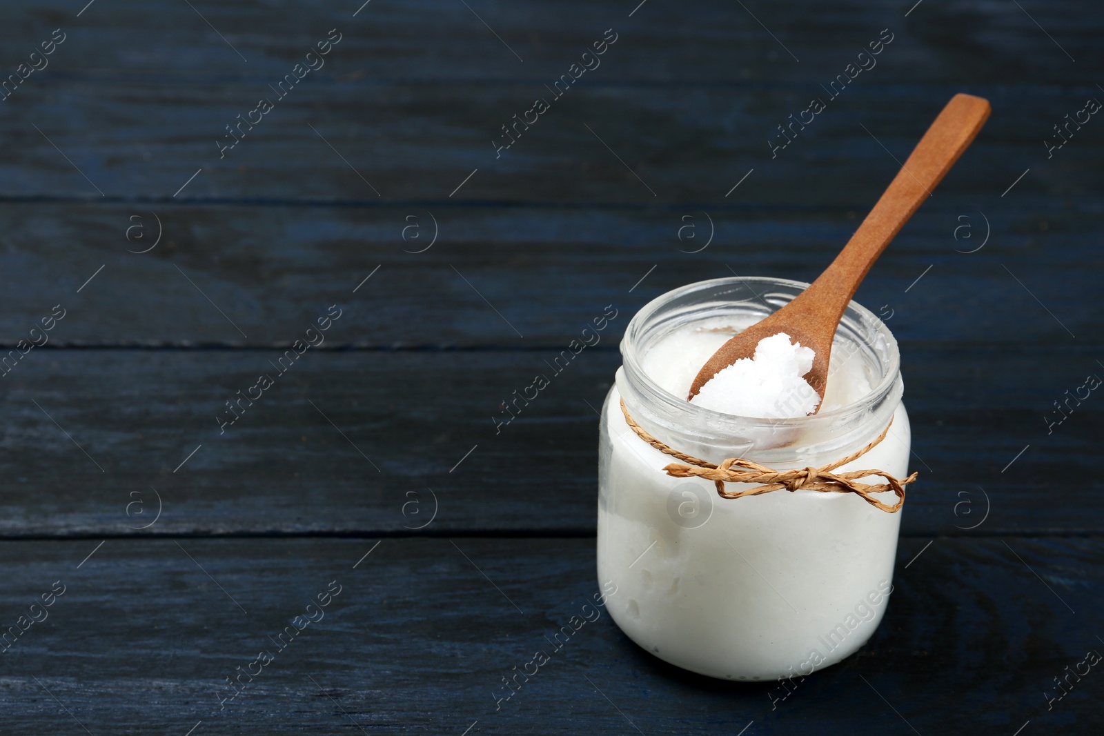 Photo of Coconut oil on dark wooden table, space for text. Cooking ingredient