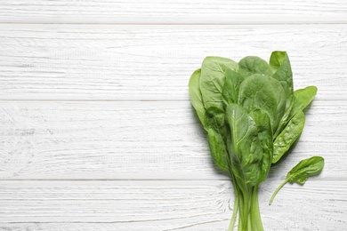 Photo of Fresh green healthy spinach on white wooden table, top view. Space for text