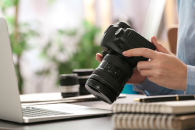 Journalist with camera working at table, closeup