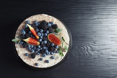 Photo of Delicious homemade cake with fresh berries and space for text on dark wooden table, top view