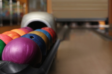 Photo of Rack with different balls in bowling club. Space for text