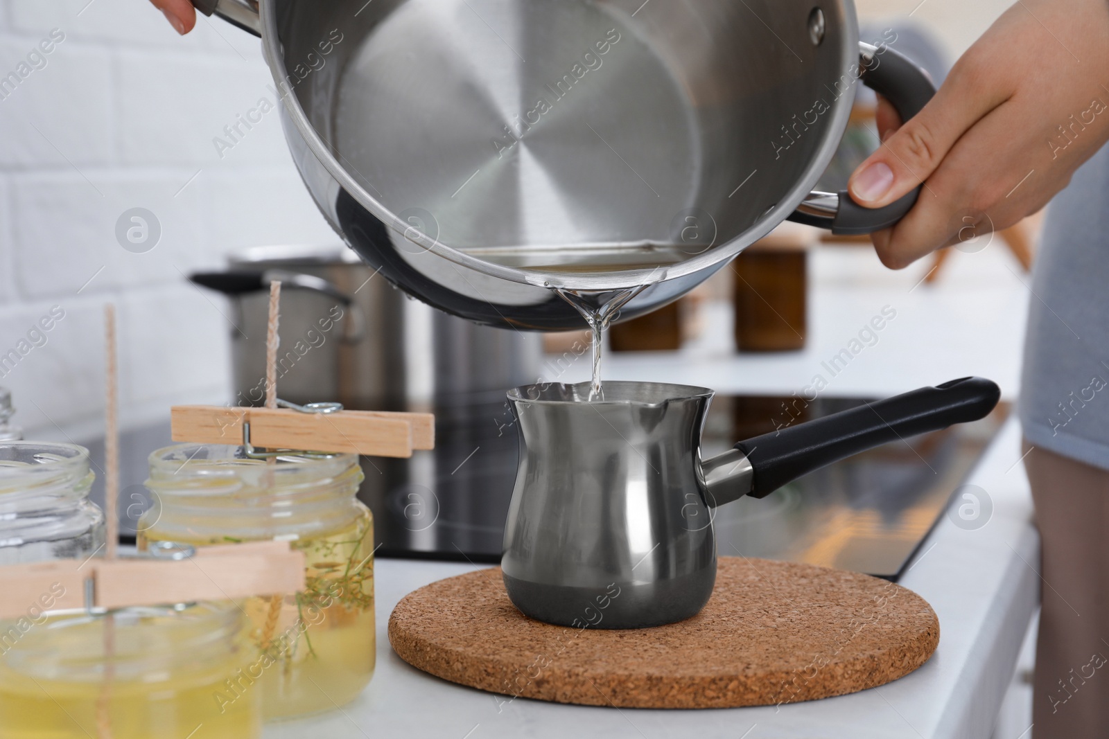 Photo of Woman making candles at white table, closeup