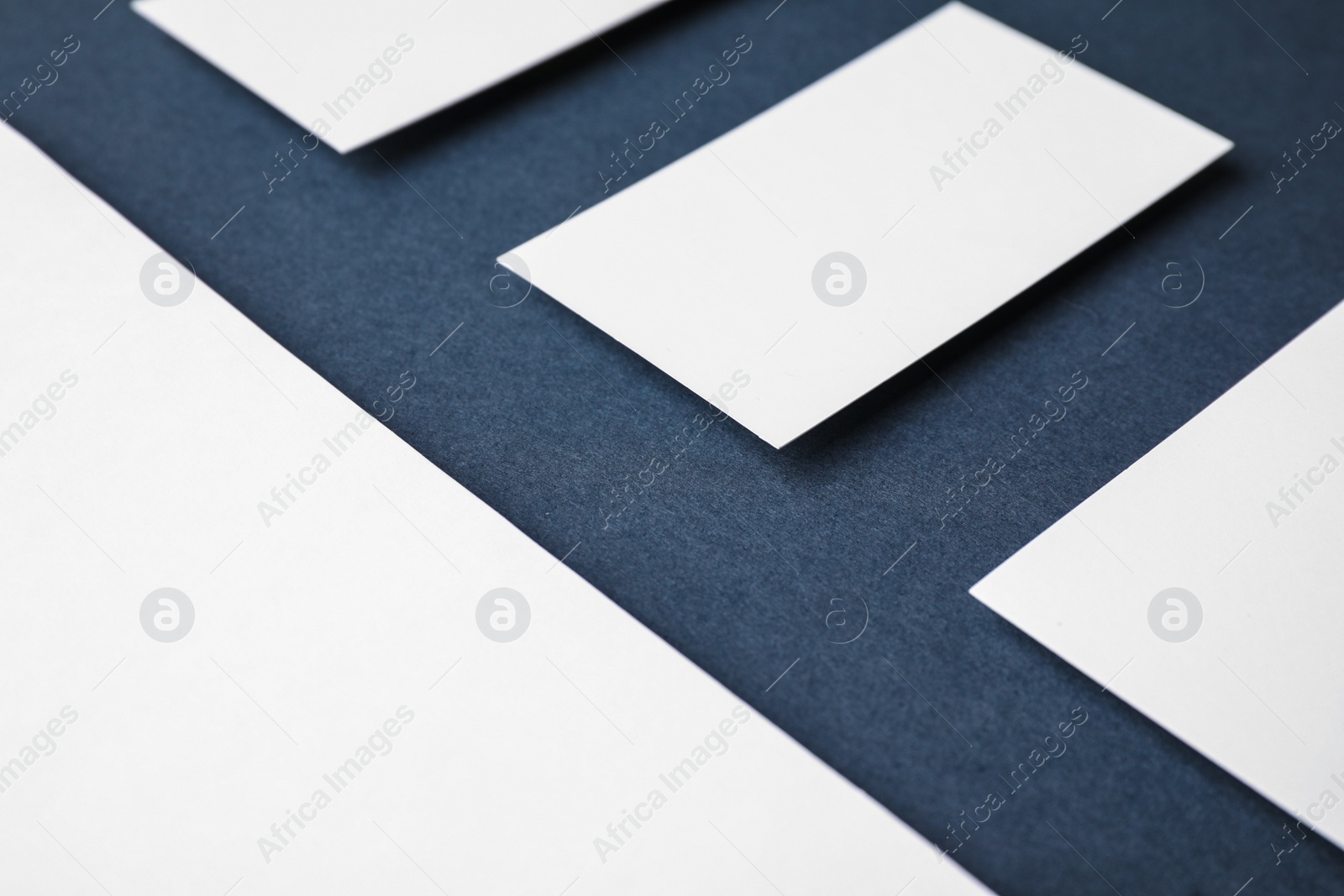 Photo of Blank business cards and paper sheet on dark grey background, closeup. Mock up for design