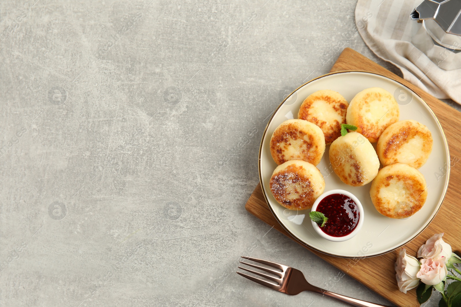 Photo of Delicious cottage cheese pancakes with jam and icing sugar on light grey table, flat lay. Space for text