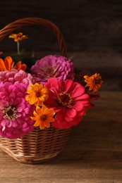 Beautiful wild flowers in wicker basket on wooden table