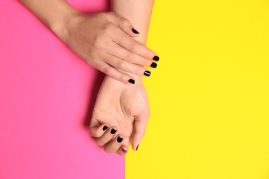 Photo of Woman showing black manicure on color background, top view with space for text. Nail polish trends