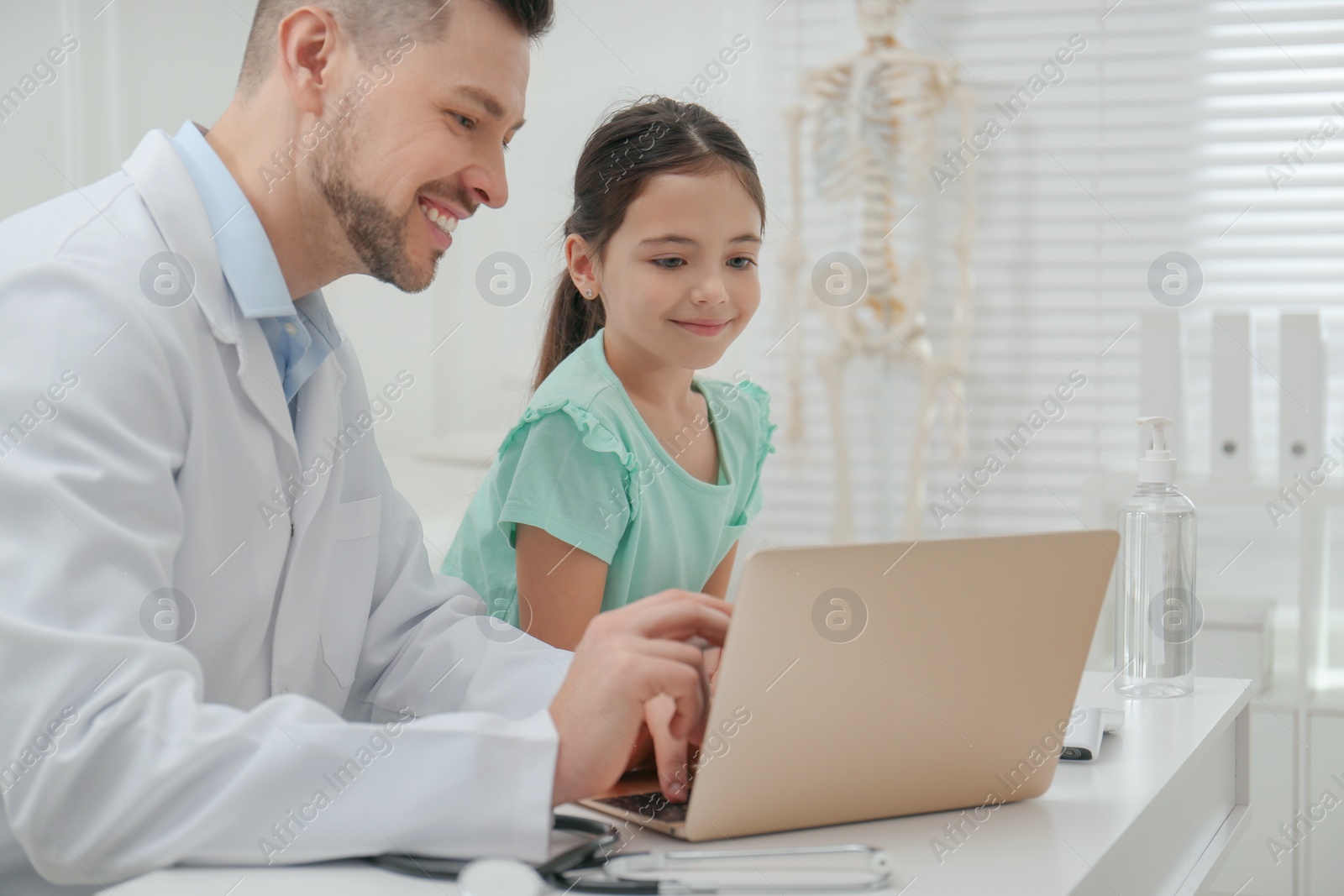 Photo of Pediatrician explaining physical examination result to little girl in hospital