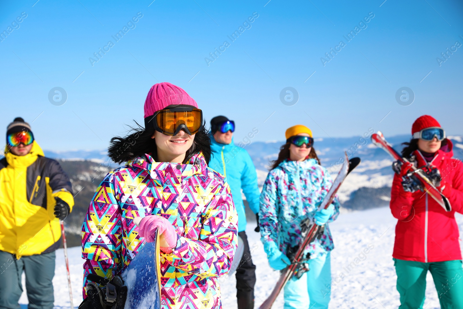 Photo of Young woman with snowboard at ski resort. Winter vacation