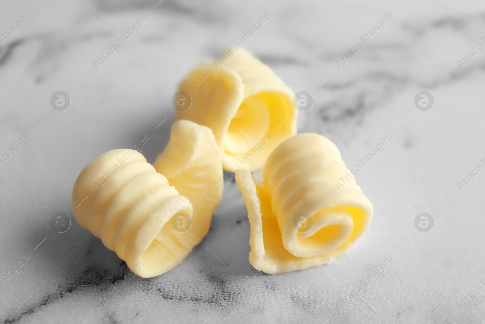 Photo of Fresh butter curls on table, closeup