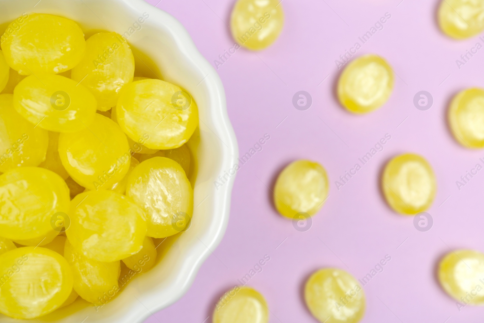 Photo of Flat lay composition with tasty lemon drops on violet background