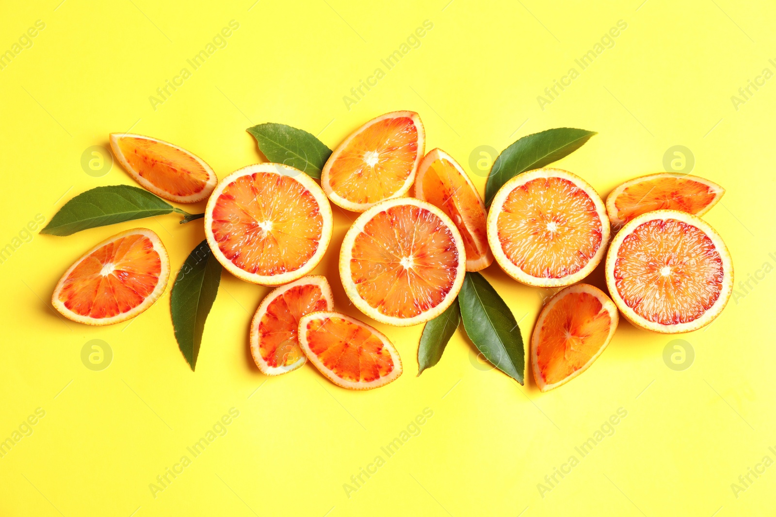 Photo of Fresh bloody oranges on color background, flat lay. Citrus fruits