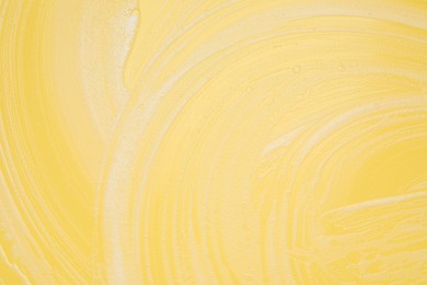 White washing foam on yellow background, top view