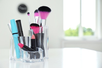 Photo of Organizer with makeup cosmetic products on table indoors. Space for text