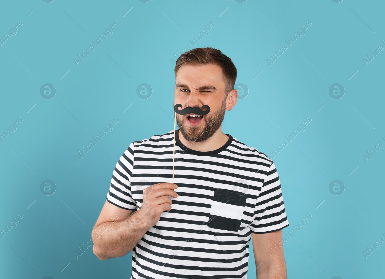 Photo of Funny man with fake mustache on turquoise background