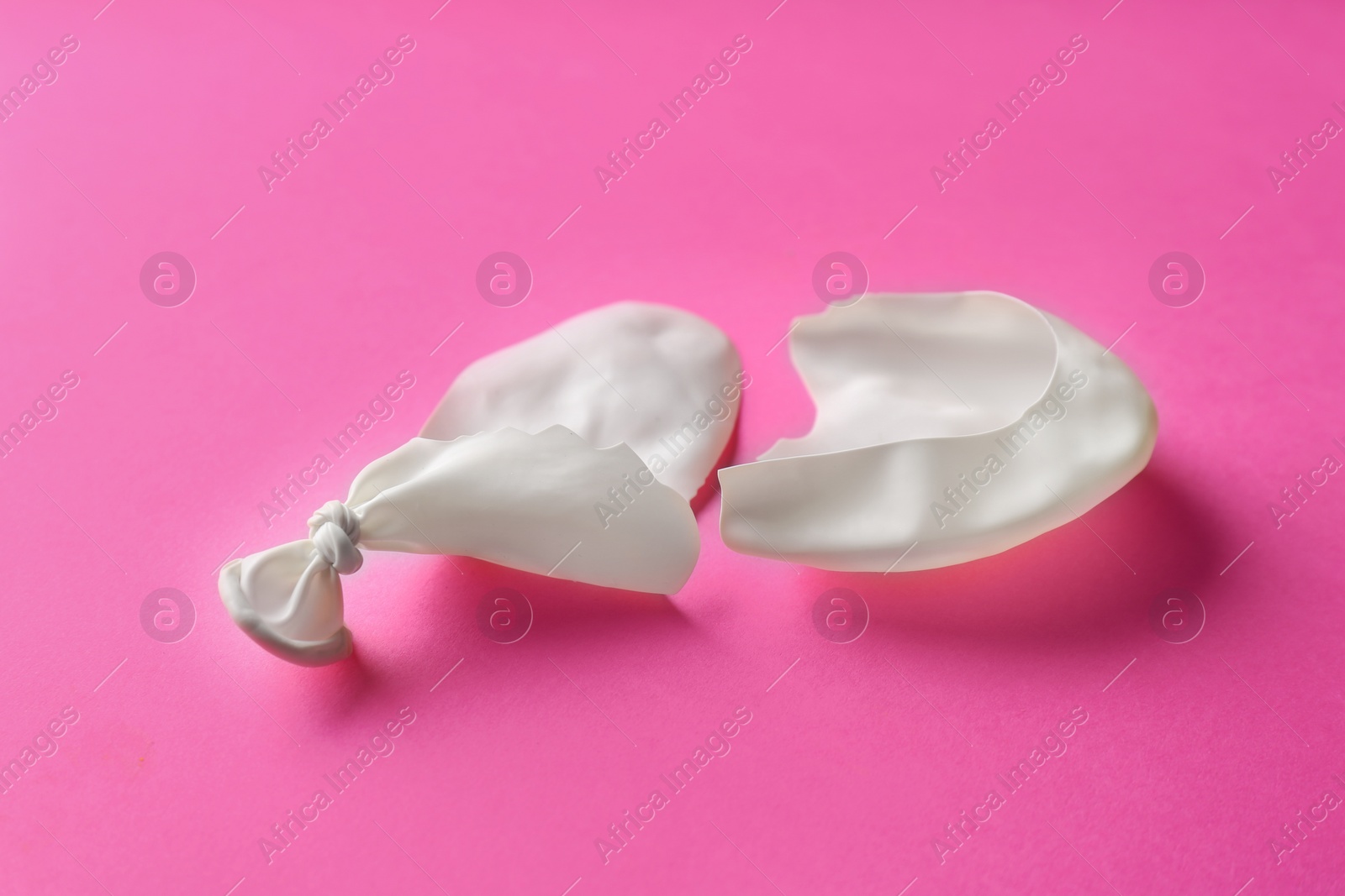 Photo of Popped white latex balloon on color background