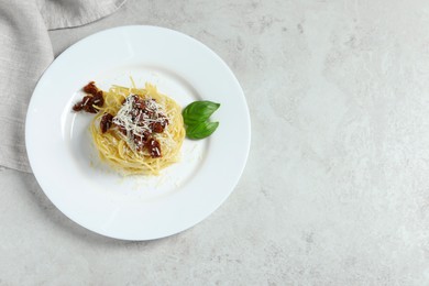Photo of Tasty spaghetti with sun-dried tomatoes and parmesan cheese on white table, top view and space for text. Exquisite presentation of pasta dish