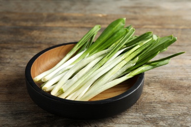 Plate with wild garlic or ramson on wooden table