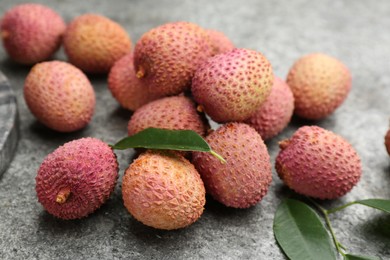 Photo of Fresh ripe lychee fruits on grey table, closeup