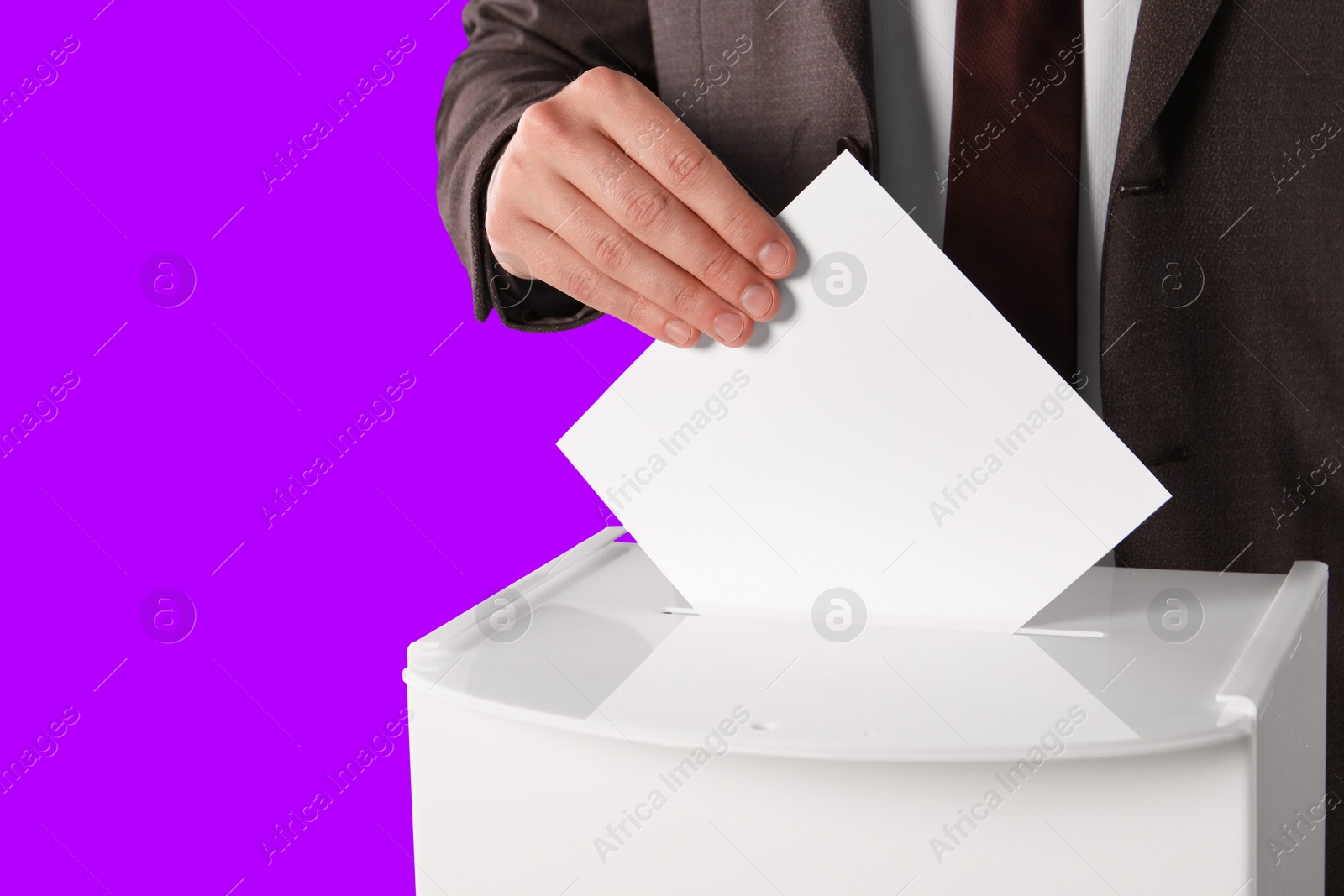 Image of Man putting his vote into ballot box on violet background, closeup