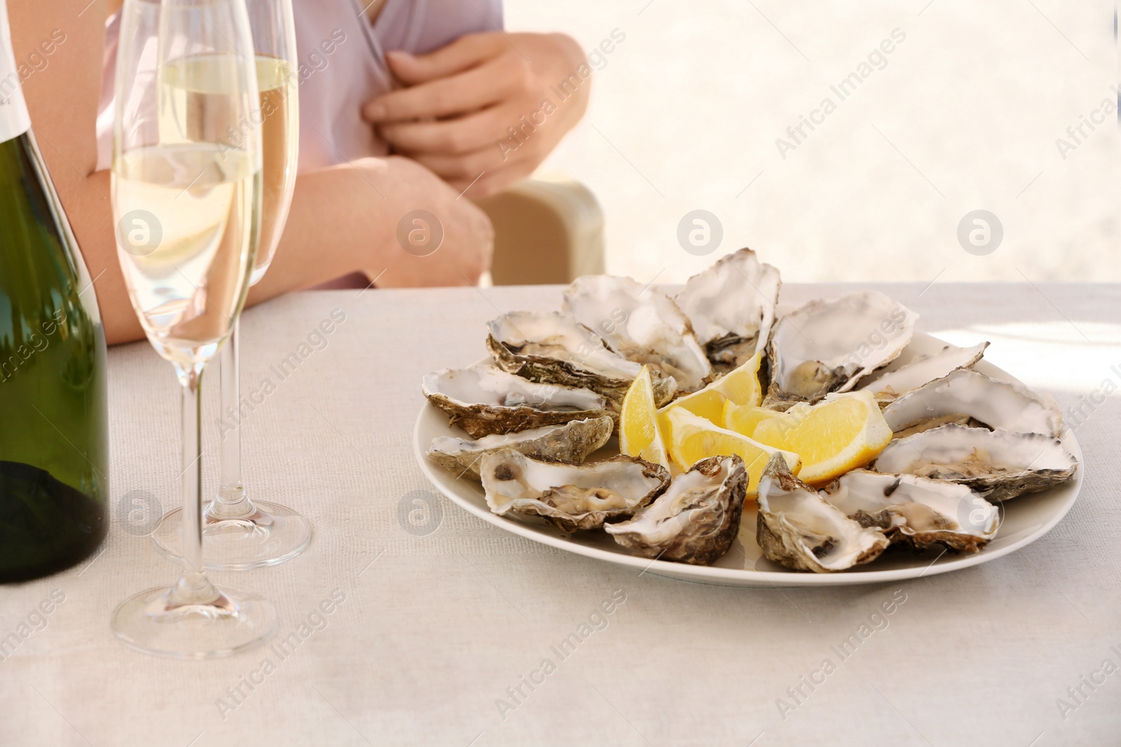 Photo of Fresh oysters with cut juicy lemon served on table