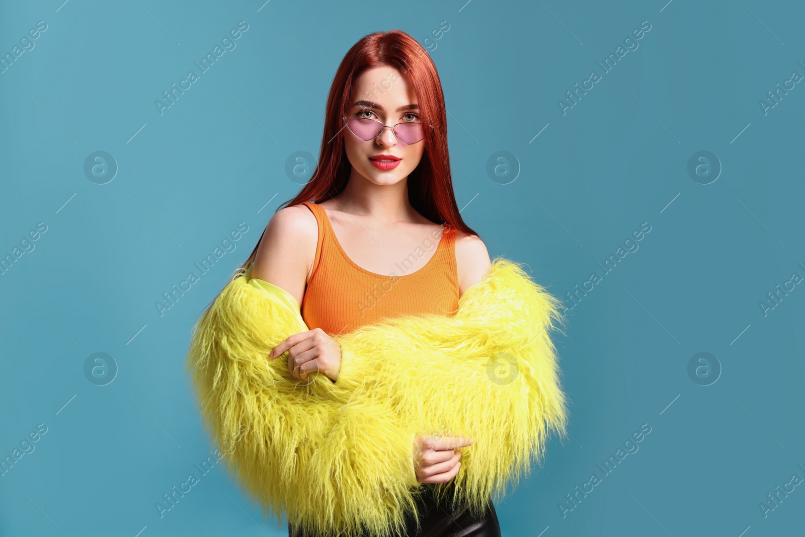 Photo of Stylish woman with red dyed hair on light blue background