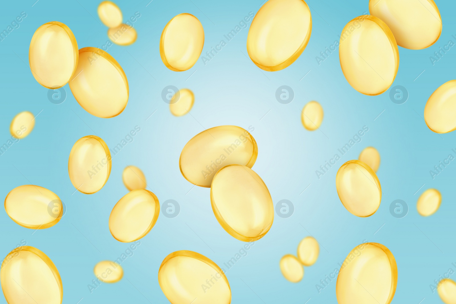 Image of Vitamin. Softgel capsules falling on light blue gradient background