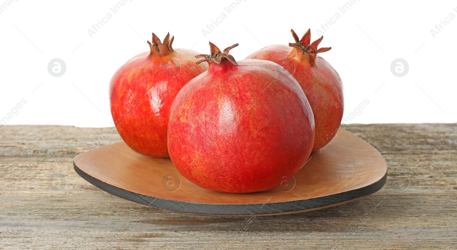 Photo of Fresh pomegranates on wooden table against white background