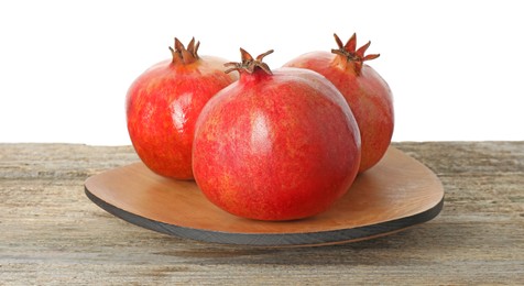 Fresh pomegranates on wooden table against white background