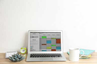 Photo of Modern laptop with calendar app in office