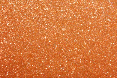 Beautiful shiny orange glitter as background, closeup