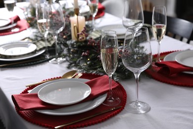 Photo of Christmas table setting with festive decor and dishware