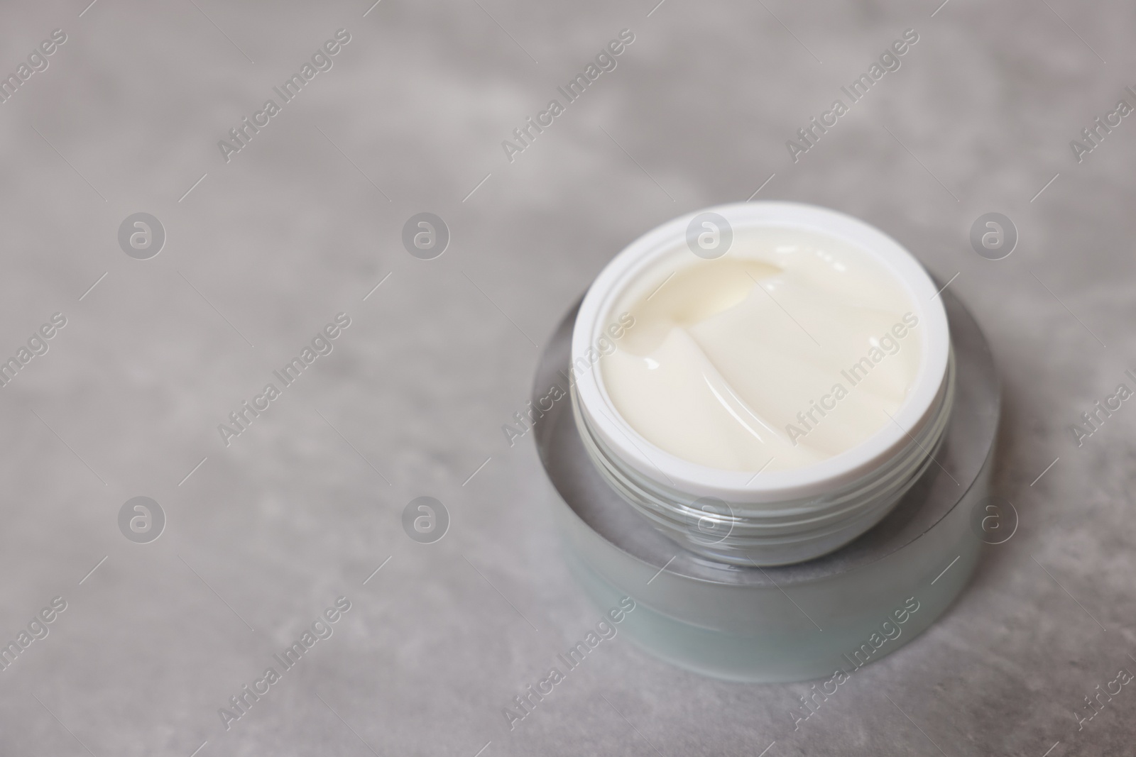 Photo of Body cream on grey table, closeup. Space for text