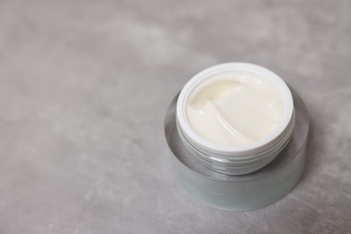 Photo of Body cream on grey table, closeup. Space for text