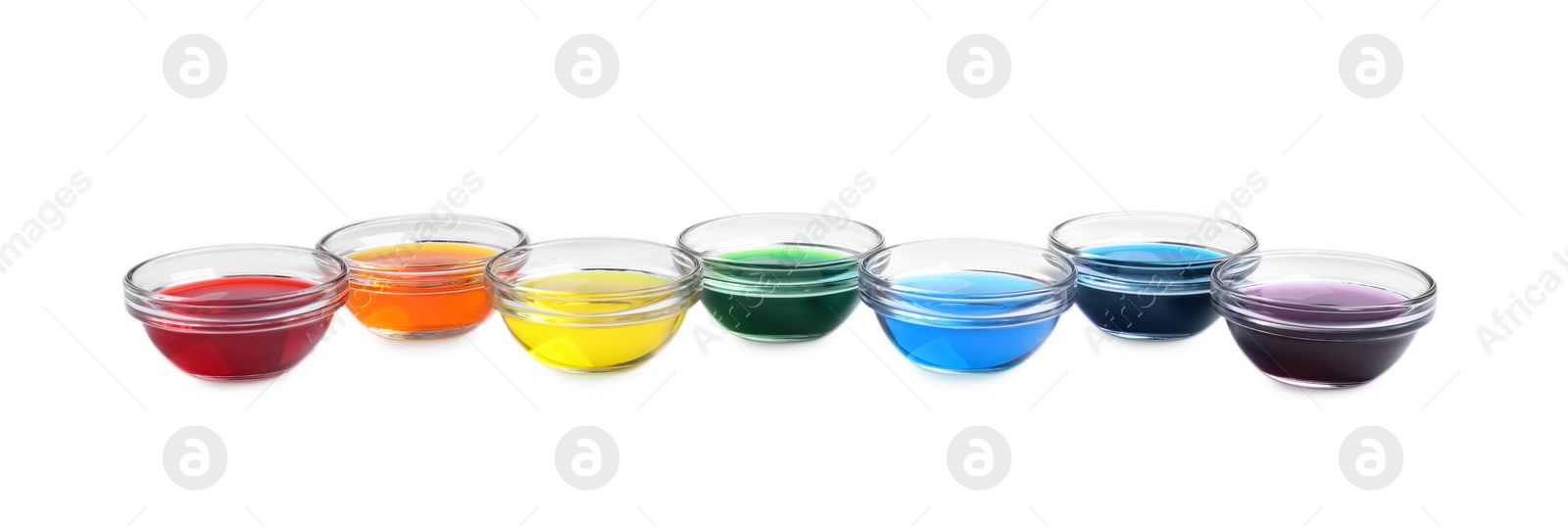 Photo of Glass bowls with different food coloring on white background