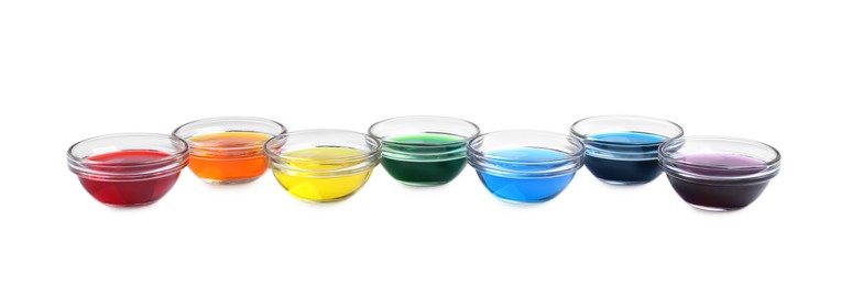 Glass bowls with different food coloring on white background