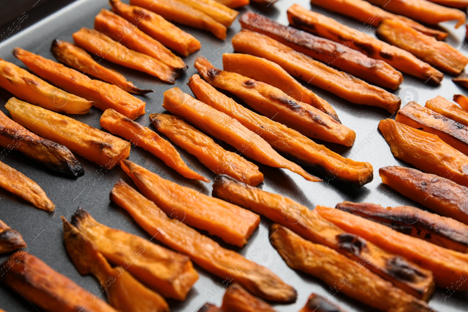 Photo of Baking sheet with sweet potato slices, closeup