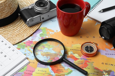 Different travel accessories on world map, closeup. Planning summer vacation trip