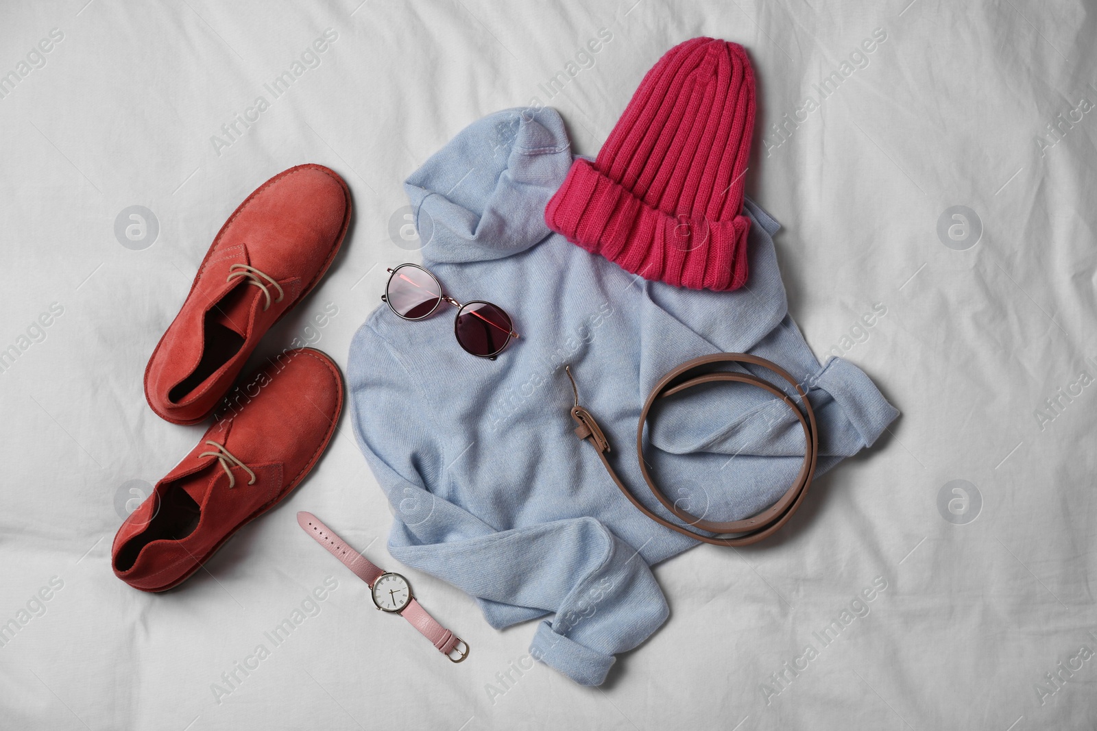 Photo of Stylish look with cashmere sweater, flat lay. Women's clothes and accessories on fabric