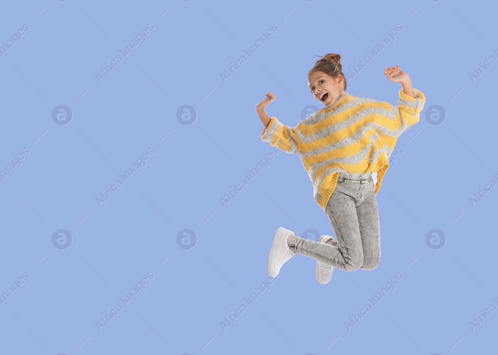 Image of Cute girl jumping on light blue background, space for text