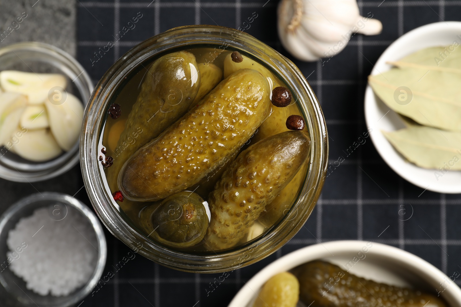 Photo of Tasty pickled cucumbers in glass jar on table, top view