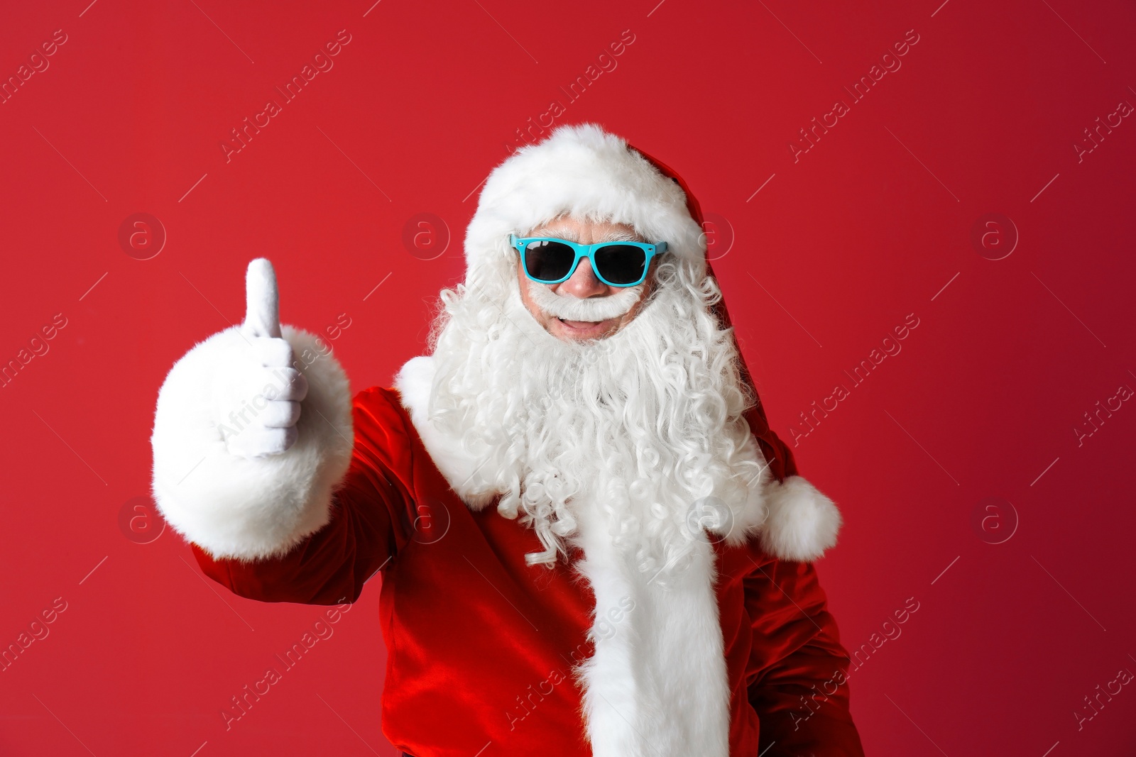 Photo of Authentic Santa Claus wearing sunglasses on color background