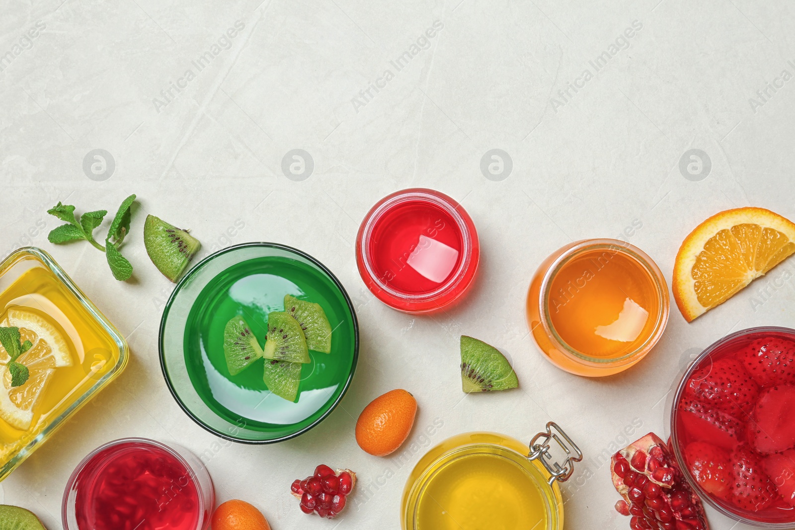 Photo of Flat lay composition with different jelly desserts on light background